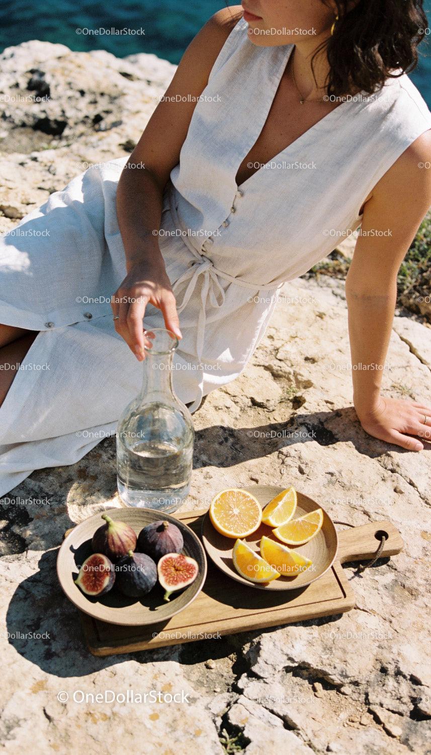 Woman Relaxing Outdoors with Fresh Fruit and Water