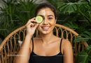 Beautiful Woman with Facial Mask Holding Cucumber in Natural Setting
