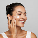 Young Woman Applying Facial Moisturizer for Healthy Glowing Skin