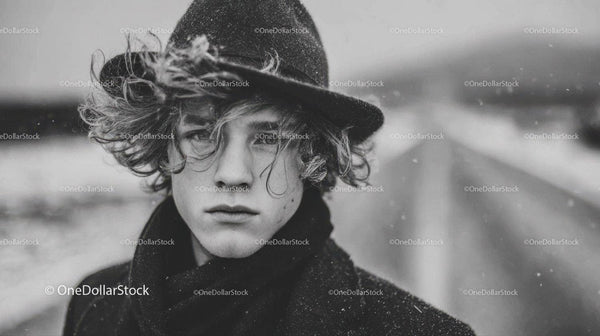 Stylish Young Man in Wide-Brimmed Hat and Wool Coat in Winter Scene