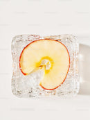Frozen apple slice trapped inside a clear ice cube