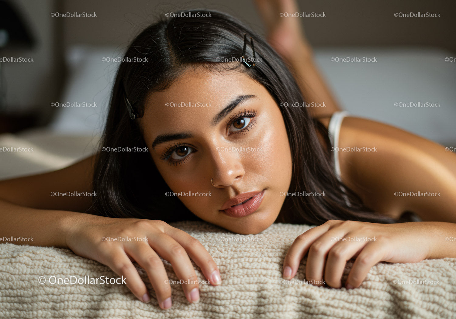 Portret młodej kobiety leżącej na przytulnym łóżku w ciepłym, naturalnym świetle