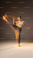 Focused woman practicing high kick in motion blur