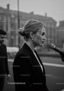 Stylish Woman in Black Blazer Speaking Outdoors in City