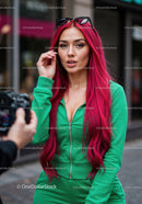 Vibrant Red Hair Woman in Green Tracksuit with Sunglasses in City