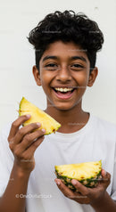 Smiling Boy Holding Fresh Pineapple Slices in Bright Casual Setting