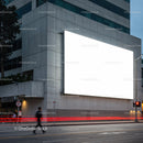 Urban street with large blank billboard on concrete wall