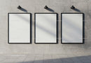 Three Blank Frames on Concrete Wall with Industrial Lamps