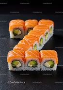 Fresh salmon avocado sushi rolls on black slate