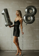 Elegant young woman celebrating 18th birthday with balloons