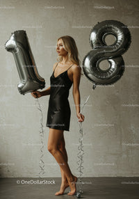 Elegant young woman celebrating 18th birthday with balloons