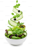 Fresh mixed green salad with cucumber ribbons and olives