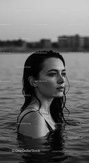 Serene Black and White Portrait of Woman in Water with City Skyline
