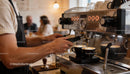 Barista preparing fresh espresso in cozy cafe setting