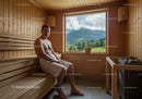 Man Sitting in Wooden Sauna with Mountain View in Nature Setting
