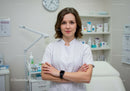 Confident Female Nurse with Arms Crossed in Modern Clinic