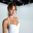 Portrait of a Smiling Young Woman in White Top Against Studio Background