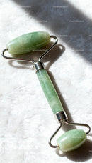 Natural jade facial roller resting on soft fabric