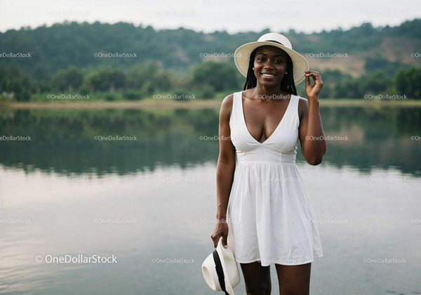 Joyful Woman in White Dress with Sunhat by Lake in Summer
