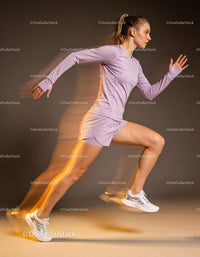 Athletic woman sprinting forward in motion blur