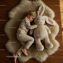 Sleeping Child Cuddling Large Plush Bunny on Rug
