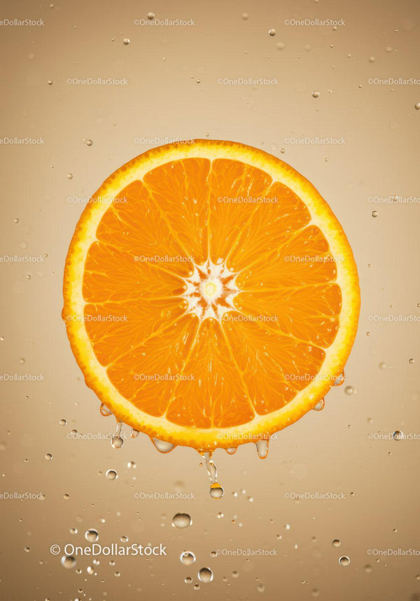 Fresh orange slice with water droplets in clear liquid