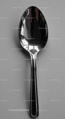 Reflective stainless steel spoon on gray surface
