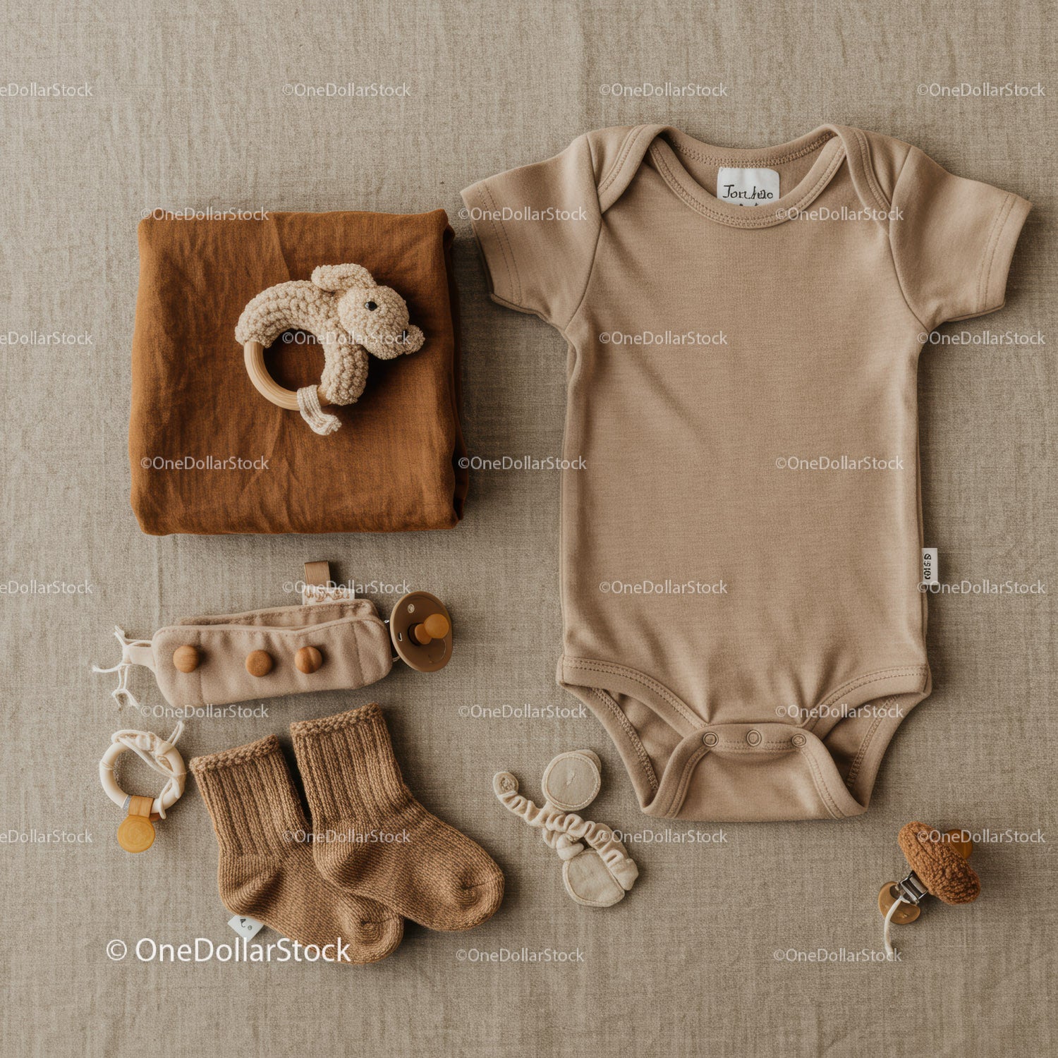 Neutral toned baby clothing and accessories flat lay