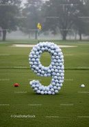 Golf balls arranged as number nine on putting green