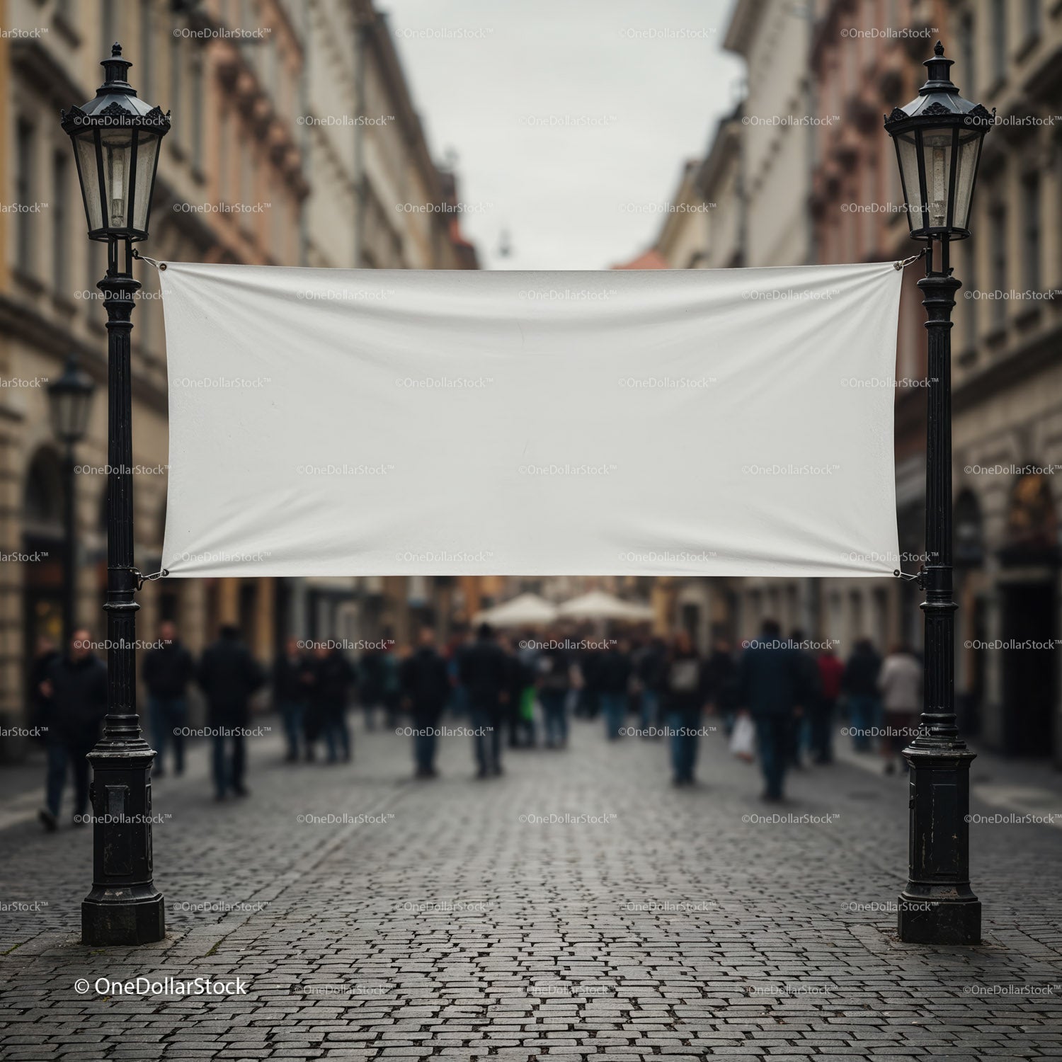 Pusty, biały baner wiszący pomiędzy zabytkowymi latarniami ulicznymi