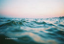 Calm Ocean with Gentle Waves Under Pink Sunset Sky