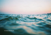 Calm Ocean with Gentle Waves Under Pink Sunset Sky