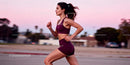 Athletic woman running outdoors during sunset