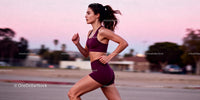Athletic woman running outdoors during sunset