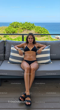 Woman in Black Bikini Relaxing on Outdoor Sofa with Ocean View