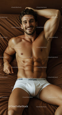 Smiling muscular man relaxing on bed in white underwear