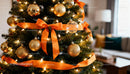 Christmas Tree Decorated with Golden Ornaments and Orange Ribbon