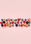 Fresh mixed berries and mint leaves on pink background