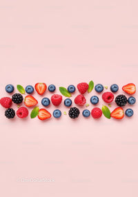 Fresh mixed berries and mint leaves on pink background