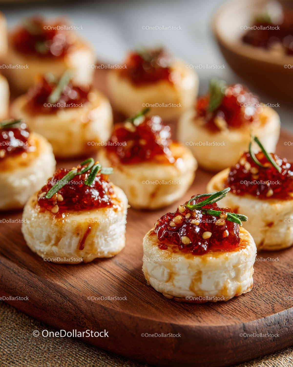 Cheese Bites with Raspberry Jam and Rosemary on Wooden Board