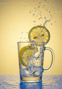 Refreshing splash of lemon water with ice cubes