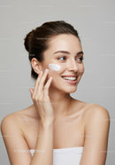Young Woman Applying Face Moisturizer for Healthy Glowing Skin