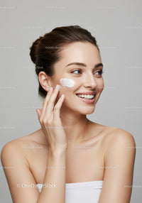 Young Woman Applying Face Moisturizer for Healthy Glowing Skin
