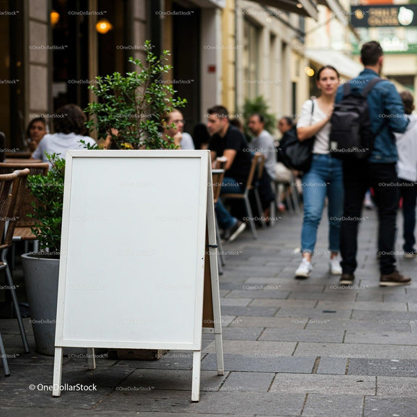 Blank white signboard outside busy street cafe JPG Mockup Image