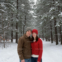 Young couple smiling in snowy pine forest
