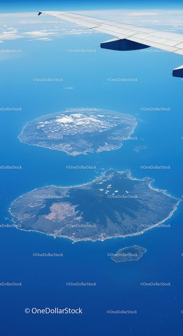 Aerial View of Volcanoes and Islands Below from an Airplane Window