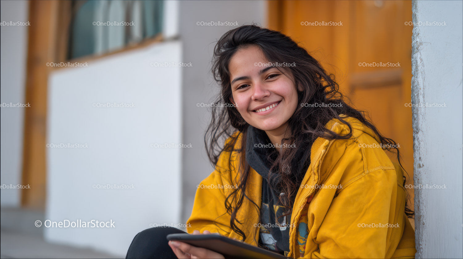 Smiling Young Woman in Yellow Jacket Sitting Outdoors
