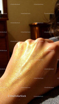 Golden highlighter glowing on hand in natural light
