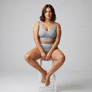 Young Woman Sitting Cross-Legged on Stool Wearing Casual Gray Sportswear