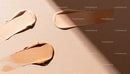 Varied shades of creamy foundation makeup on beige background